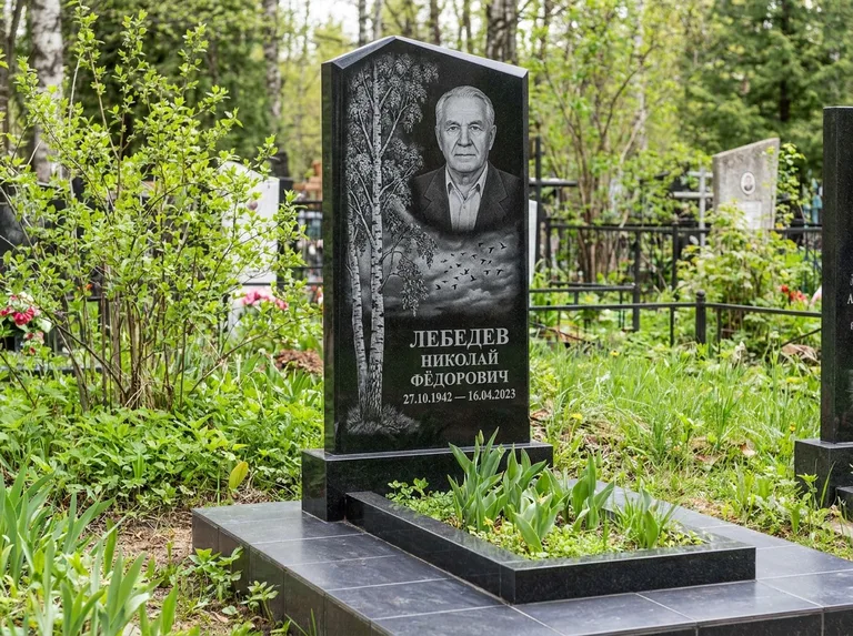 Памятник с гравировкой берёзы: вертикальная стела со скошенным верхом — берёза и стая птиц в небе, гранитный цоколь с тёмной плиткой, работа «Лебедев» в Перми