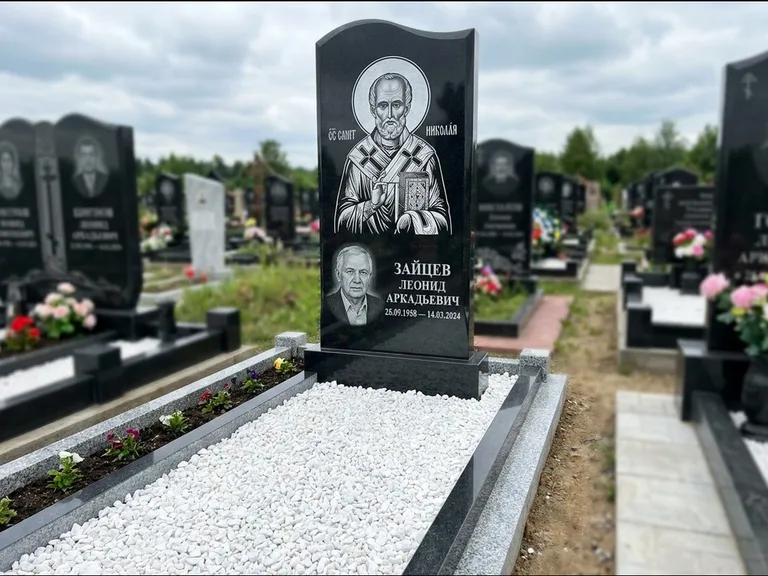 Памятник с гравировкой иконы: стела с крестообразным навершием — икона в резной рамке-киоте, газон без ограды, стриженая трава, работа «Раевская» в Перми