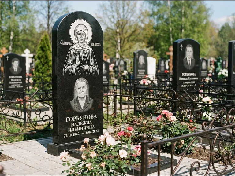 Памятник с гравировкой иконы: стела с арочным верхом и киотом под образ — гравировка образа Матроны Московской, гранитный цоколь с тёмной плиткой, работа «Ковалёв» в Перми