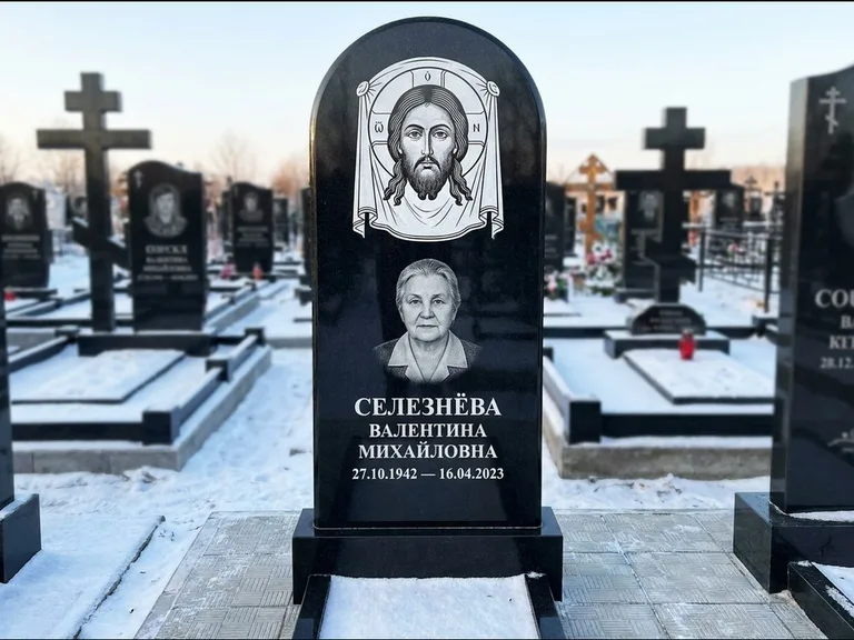 Памятник с гравировкой иконы: небольшая скромная одиночная стела с именной иконой — золочёный нимб на образе, аккуратный участок с газоном, работа «Ковалёв» в Перми