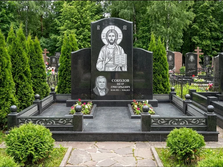 Памятник с гравировкой иконы: широкая горизонтальная лежачая плита-стела — икона в резной рамке-киоте, серая гравийная отсыпка с бордюром, работа «Богданова» в Перми