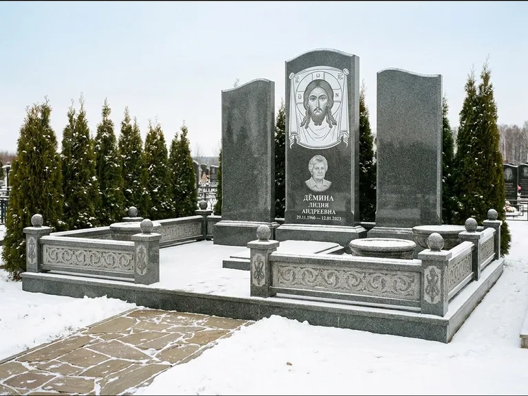 Памятник с гравировкой иконы: узкая вертикальная стела-пилон с ликом — икона в резной рамке-киоте, открытая лужайка без ограды, работа «Одинцов» в Перми