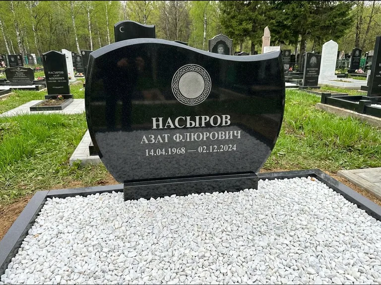 Мусульманский памятник: стела с волнообразным скошенным верхом — гравировка мечети под полумесяцем и звёздами, белая мраморная крошка с бордюром, работа «Насыров» в Перми