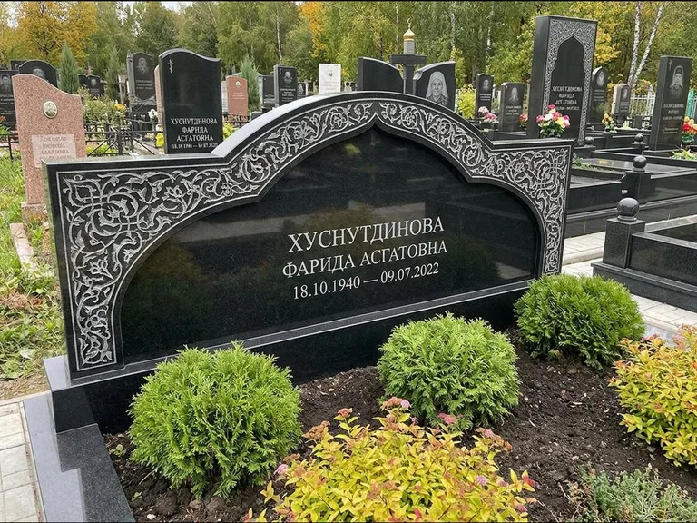 Мусульманский памятник: вытянутая горизонтальная семейная стела с аркой — белая гравировка силуэта мечети с минаретами, участок с декоративными кустами, работа «Зарипова» в Перми