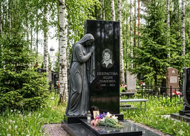 Гранитная фигура скорбящего мужчины у чёрной стелы в Перми